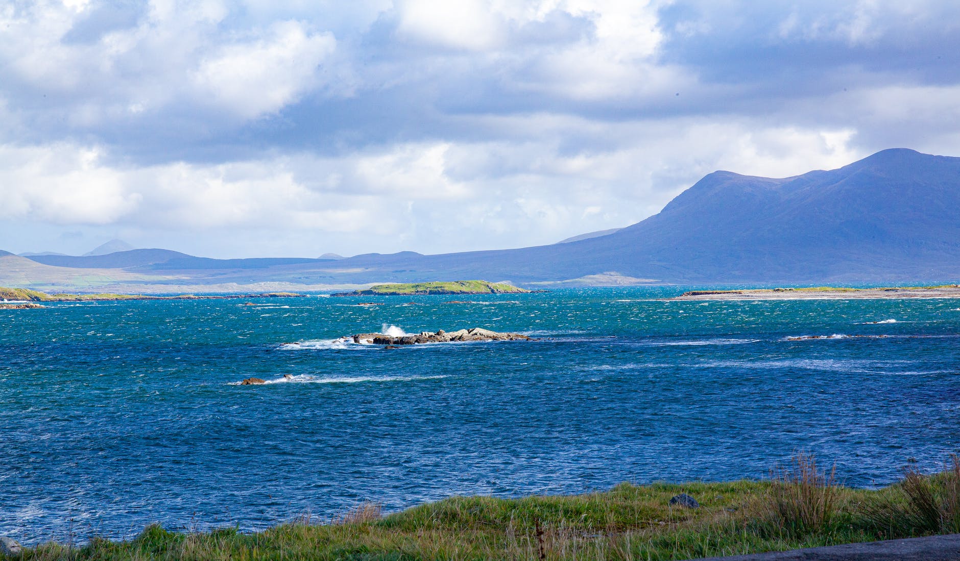 blue water of bay by mountains on shore